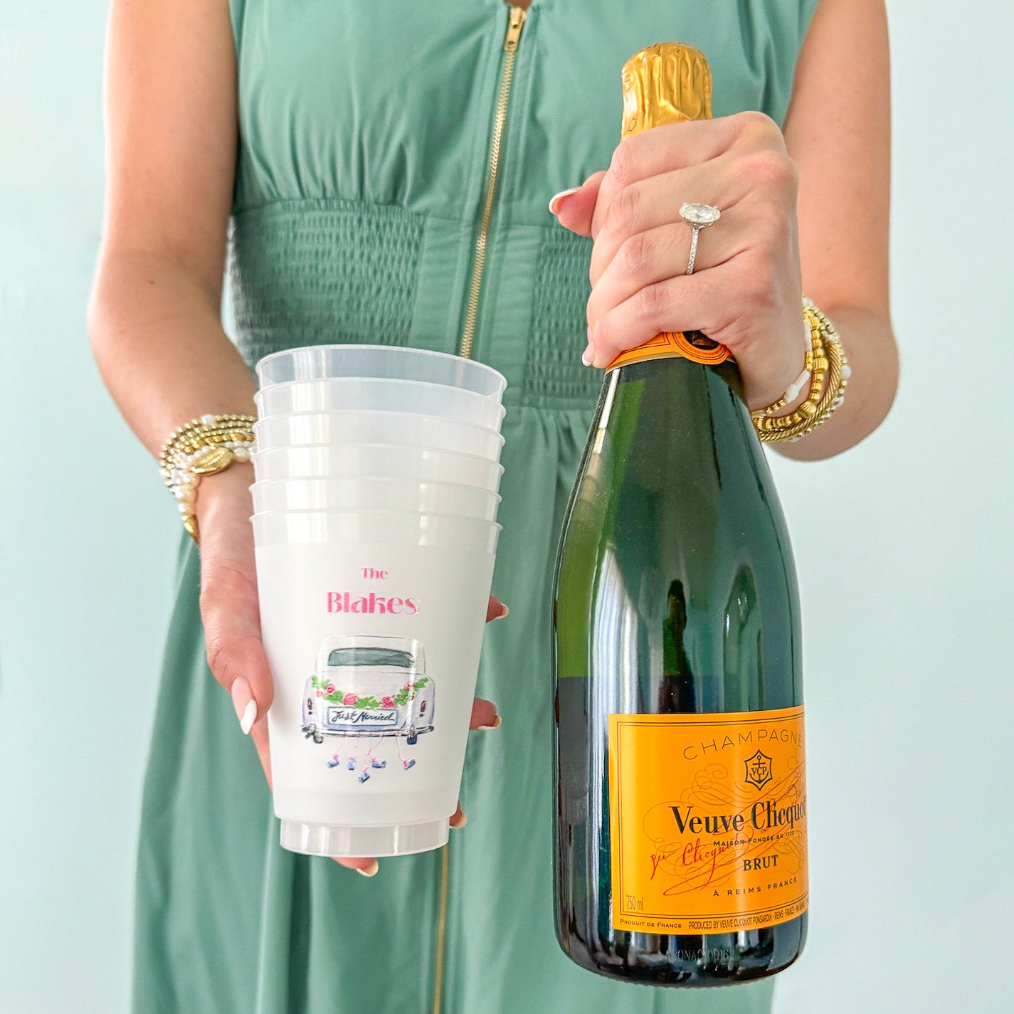 Woman holding customized frosted cups and champagne